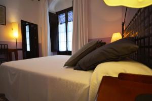 1 dormitorio con cama con almohadas y ventana en Hotel Casa de los Azulejos, en Córdoba