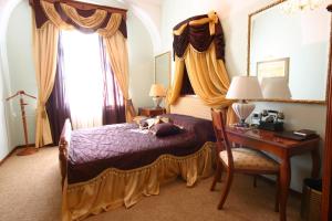 a bedroom with a canopy bed with a desk and a desk at Hotel Leopold I in Novi Sad