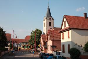 a town with a clock tower and a street with buildings at Hotel Restaurant Père Benoît in Entzheim