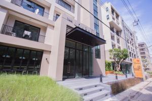 a building with a bench in front of it at The Journey Hotel Laksi in Bangkok