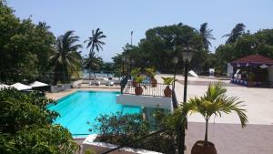 una piscina en un complejo con palmeras en Cocoa Luxury Resort, Nyali, Mombasa, en Mombasa