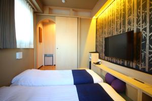 Hotel Wing International Select Asakusa Komagata في طوكيو: غرفة فندقية بسريرين وتلفزيون بشاشة مسطحة