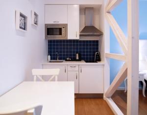 a small kitchen with white cabinets and a microwave at Rossio Apartments in Lisbon