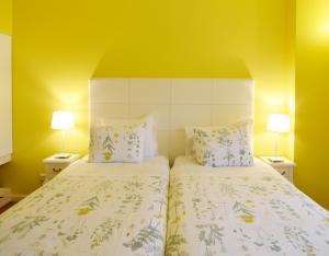 a bedroom with a bed with two pillows and two lamps at Rossio Apartments in Lisbon