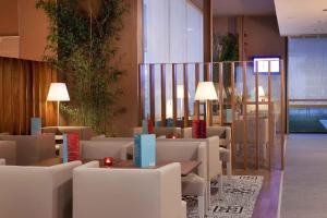 a lobby with tables and chairs in a building at Travelodge Málaga Airport in Málaga