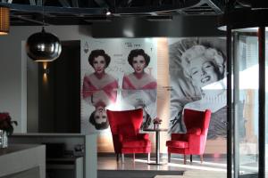 a room with red chairs and a wall with posters at Star inn Lisbon Airport in Lisbon