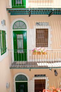 a building with a green door and a balcony at The Market Courtyard - Suites Hotel in Jerusalem