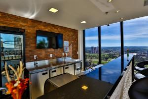 La salle de bains est pourvue d'un lavabo et offre une vue sur la ville. dans l'établissement Quality Hotel Flamboyant, à Goiânia