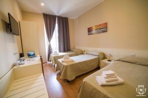 a hotel room with two beds and a television at Hotel Moderno in Lecco