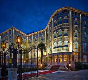 un edificio con un cancello di fronte ad esso di notte di Ausonia Hungaria Wellness & Lifestyle a Lido di Venezia