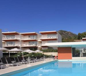 a hotel with a swimming pool with chairs and umbrellas at Sporting Club Resort in Praia a Mare