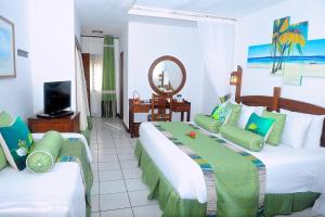 a hotel room with two beds and a television at Voyager Beach Resort in Mombasa