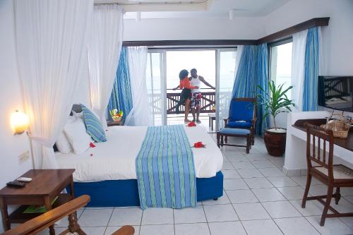 a hotel room with a bed and a balcony at Voyager Beach Resort in Mombasa