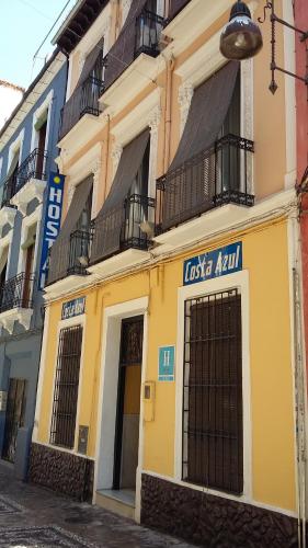 un edificio amarillo con balcones en una calle en Hostal Costa Azul, en Granada