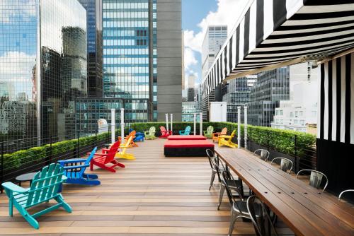 una terrazza con sedie e tavoli colorati in una città di Pod 51 a New York