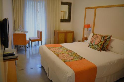 a hotel room with a large bed and a table at Mine Hotel in Buenos Aires