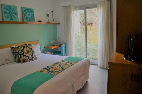 a bedroom with a bed and a large window at Mine Hotel in Buenos Aires