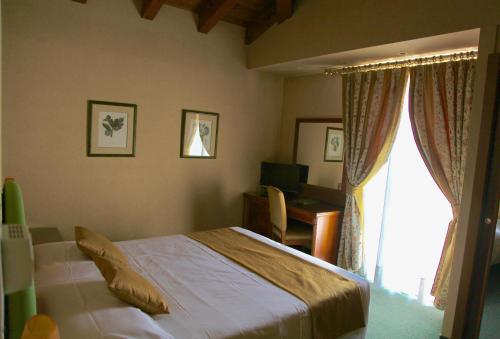 a bedroom with a bed and a desk and a window at Santanna in Verbania