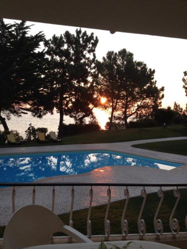 von einem Balkon mit Blick auf den Pool und den Sonnenuntergang in der Unterkunft Troia Apartments in Troia