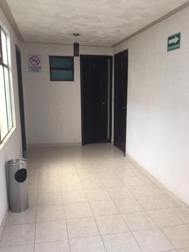 an empty room with a black door and a tile floor at Hotel Oxford in Mexico City