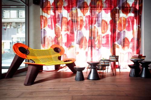 a wooden chair sitting in front of a window at BOMA easy living hotel in Strasbourg