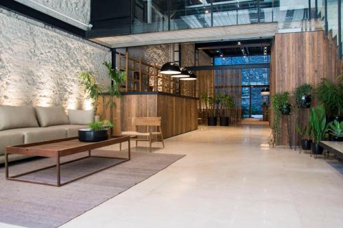 a lobby with a couch and tables and plants at AQ Tailored Suites in Buenos Aires