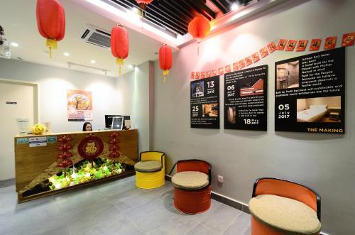 a restaurant with two stools and a counter with flowers at Artisan Eco Hotel in Petaling Jaya