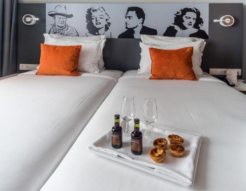 two beds with drinks and donuts and wine glasses at Star inn Lisbon Airport in Lisbon