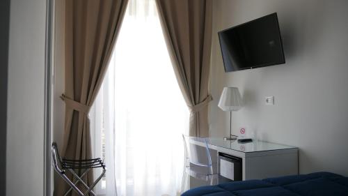 a living room with a large window with a television at Domus Nova in Reggio di Calabria