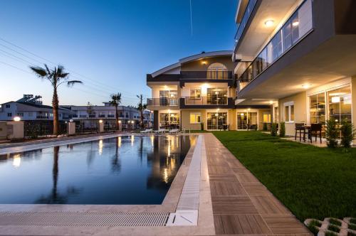 uma casa grande com uma piscina em frente em Lara Beach Homes em Antália