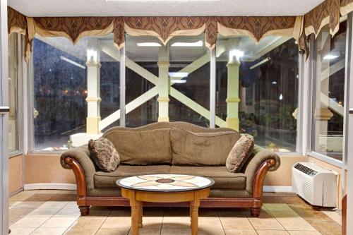 a living room with a couch and a table in front of a window at Days Inn by Wyndham Knoxville West in Knoxville