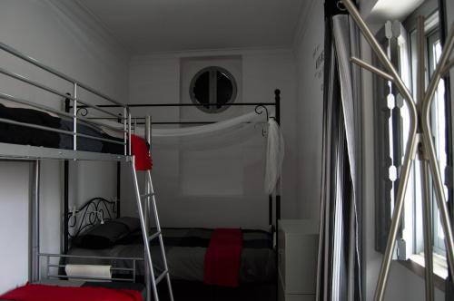 a bedroom with two bunk beds and a mirror at Lisbon Hostel Terminal 3 in Lisbon