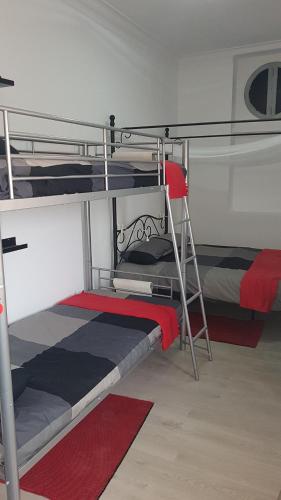 a bedroom with two bunk beds and a ladder at Lisbon Hostel Terminal 3 in Lisbon