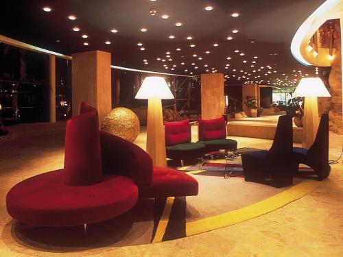 a lobby with chairs and lamps in a building at Dan Eilat Hotel in Eilat