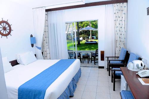 a hotel room with a bed and a table and chairs at Voyager Beach Resort in Mombasa