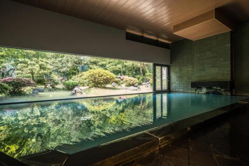 an infinity pool in a house with a large window at Takamiya Bettei Kuon in Tsuruoka