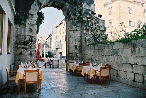 łuk ze stołami i krzesłami w budynku w obiekcie Hotel Peristil w Splicie