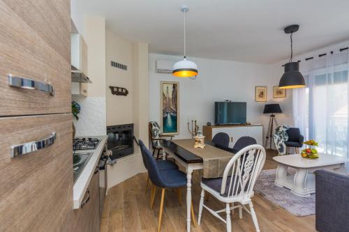 uma cozinha e sala de estar com mesa e cadeiras em Apartments Marta 1 em Zadar