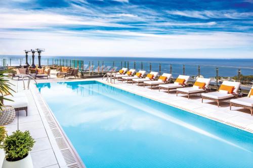 een zwembad met stoelen en de oceaan op de achtergrond bij Hotel X Toronto by Library Hotel Collection in Toronto