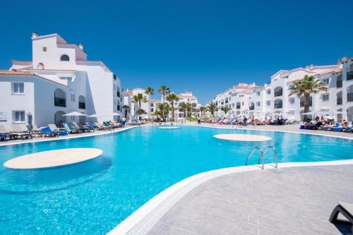 a swimming pool in the middle of a resort at Fergus Style Carema Beach in Cala'n Bosch