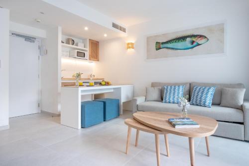 a living room with a couch and a table at Fergus Style Carema Beach in Cala'n Bosch