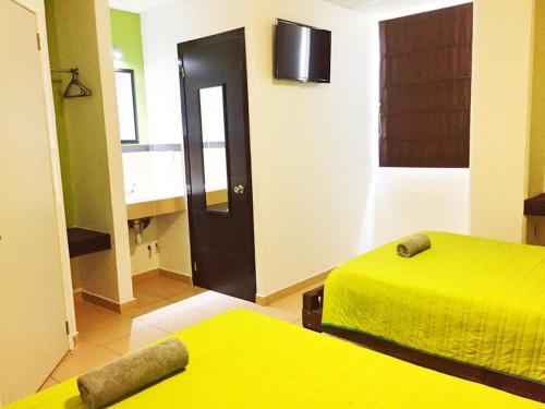 a room with two beds and a black door at Hotel Plazha in Tuxtla Gutiérrez