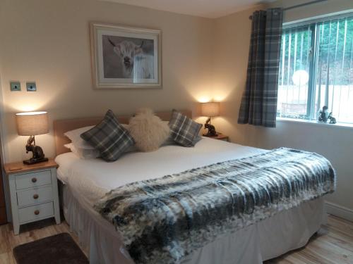 a bedroom with a bed with a blanket on it at The Stables - Deer Park Farm in Solihull