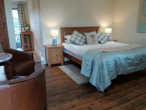 a bedroom with a bed and a couch and a chair at The Stables - Deer Park Farm in Solihull