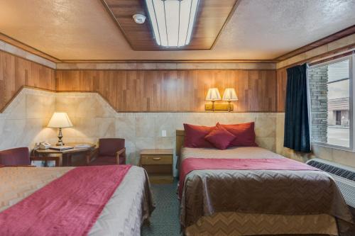 a hotel room with two beds and a desk and a window at Zion Park Motel in Springdale