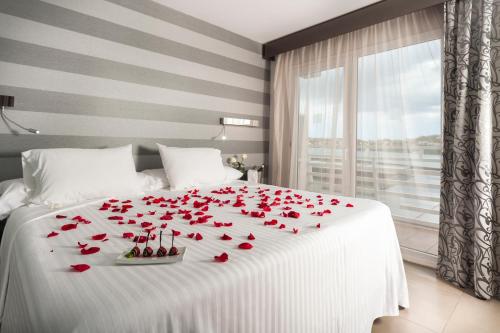 un letto bianco con rose rosse sopra di Barceló Hamilton Menorca - Adults Only a Es Castell