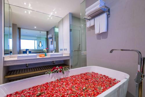 a bathroom with a tub filled with red roses at Wyndham Grand Phuket Kalim Bay in Patong Beach