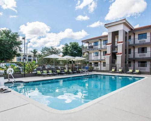 een zwembad met stoelen en parasols in een hotel bij Quality Inn & Suites By the Parks in Orlando