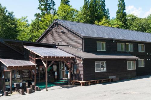 a large wooden building with a gambrel roof at Yachi Onsen in Towada