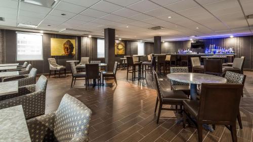 een restaurant met tafels en stoelen en een bar bij Best Western Premier NYC Gateway Hotel in North Bergen